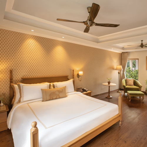 suite in manesar with a comfy king size bed, lavish interiors and wooden flooring at heritage village resort and spa