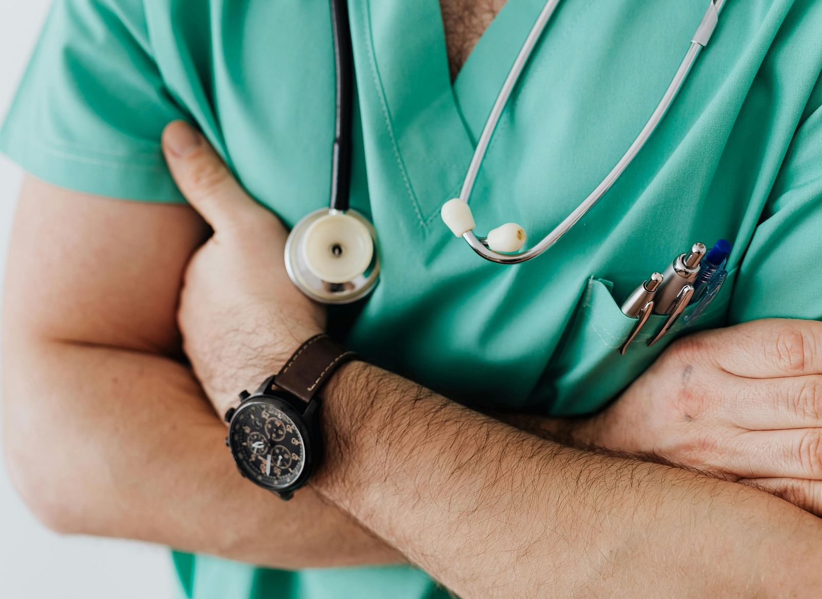 A person wearing a stethoscope around his neck and has their arms crossed.