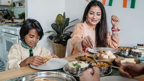 Picture featuring two people having food, multiple dishes are on the table