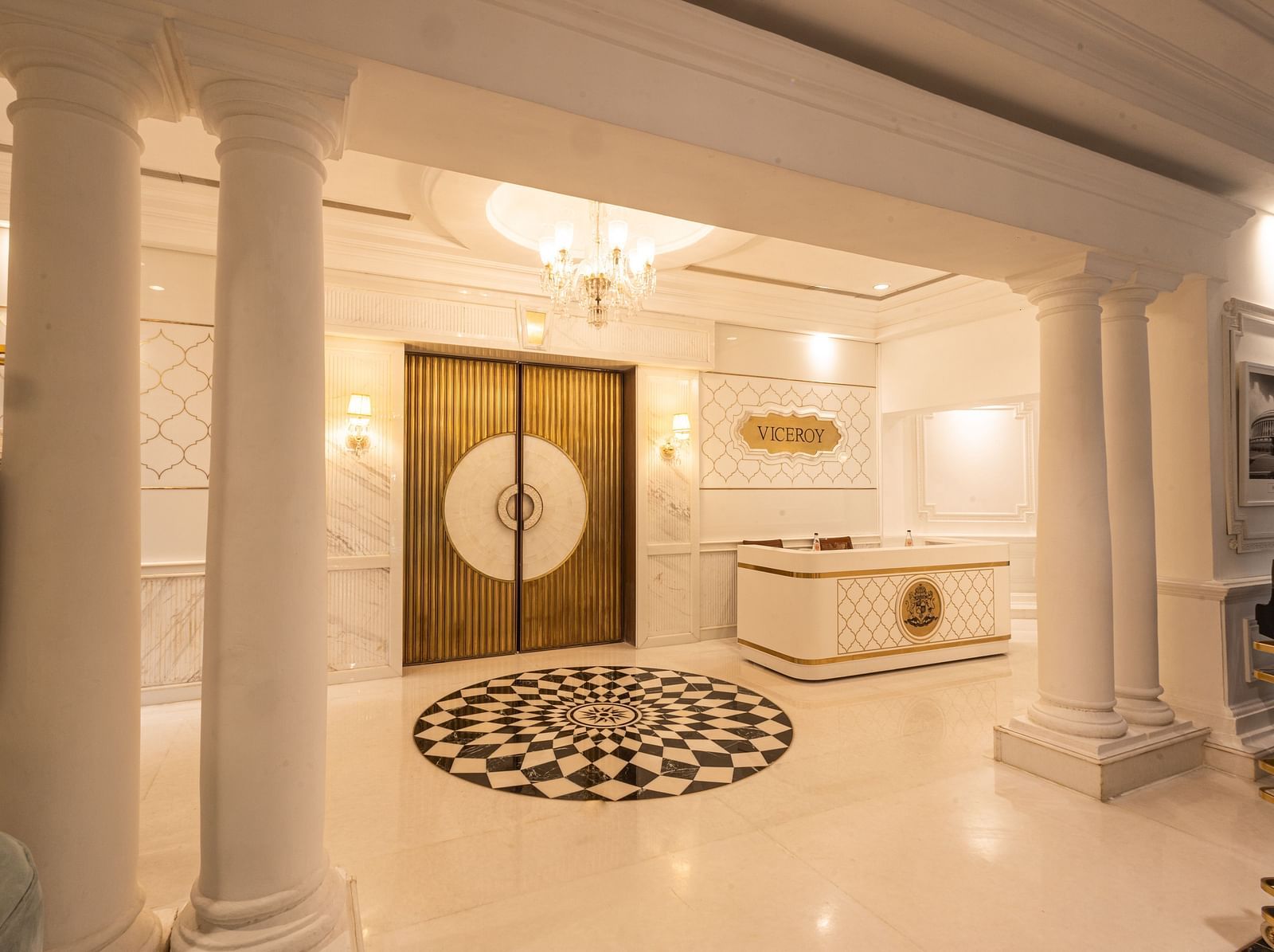 Image featuring the Viceroy Hall event venue at The Claridges New Delhi, showcasing the doorway, reception in the corner, and an elegant chandelier hanging