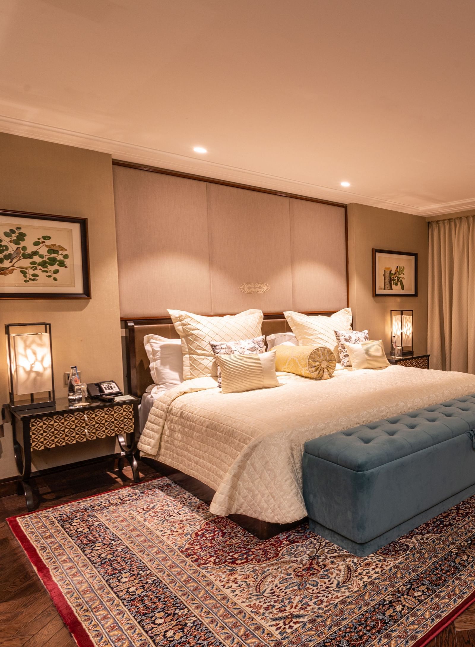 Luxury King Bed Room at The Claridges New Delhi, featuring a cosy king sized bed with plush pillows, bedside lamps, and a sofa seating area in the corner