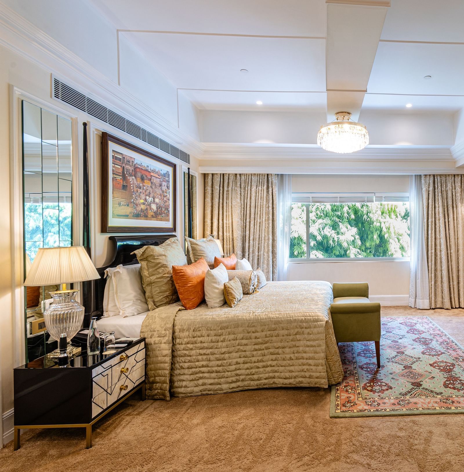 Presidential Suite at The Claridges New Delhi, featuring a king-sized bed with a bedside lamp and a wall-mounted TV