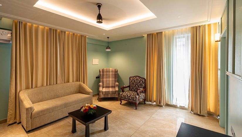 Another view of a living area with comfotable sofa and a chair in Suite room - Court 11, Kochi