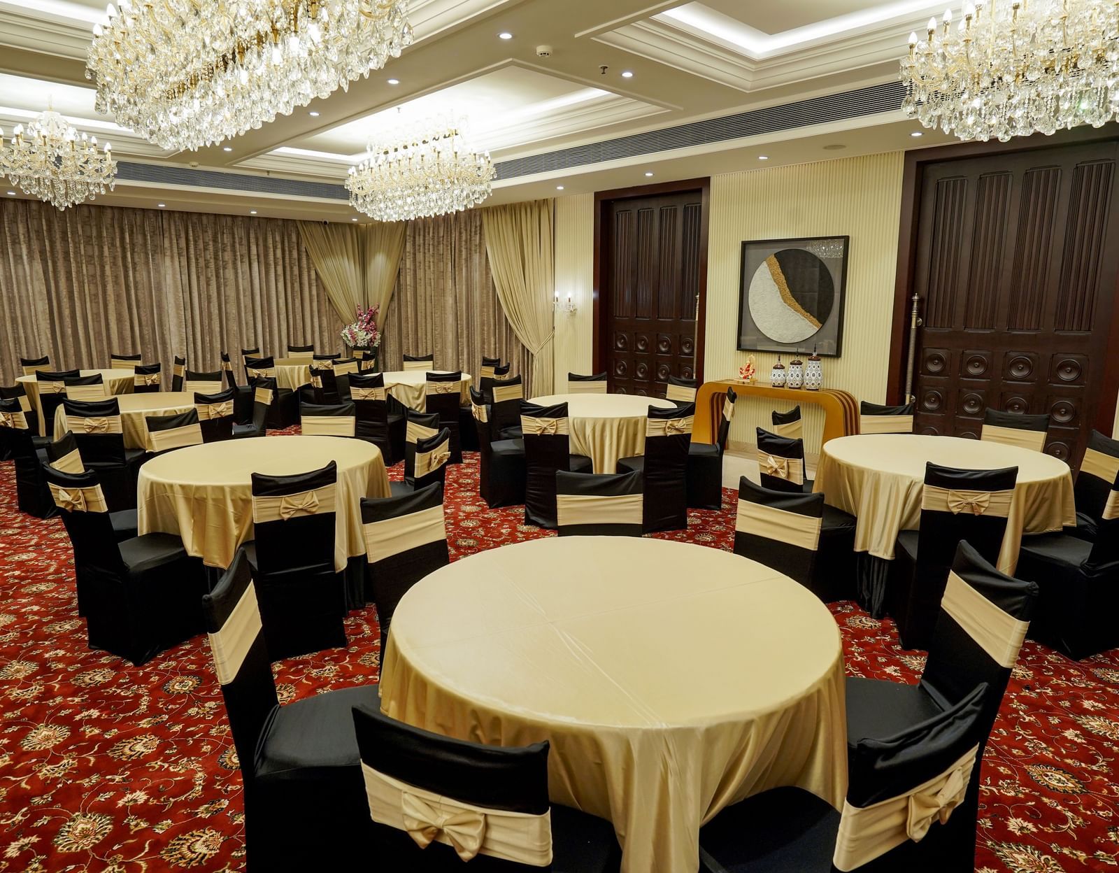 A full view shot of the Ballroom at M2 Square by Monday Premium with various round tables with golden table cloth spread over them.