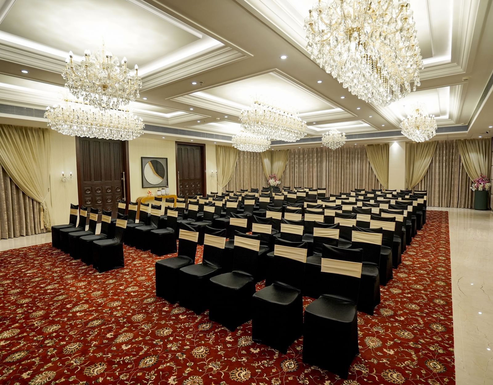 A wide angle shot of the Ballroom at M2 Square by Monday Premium with chairs arranged in a classroom setting with chandeliers hanging from the ceiling.