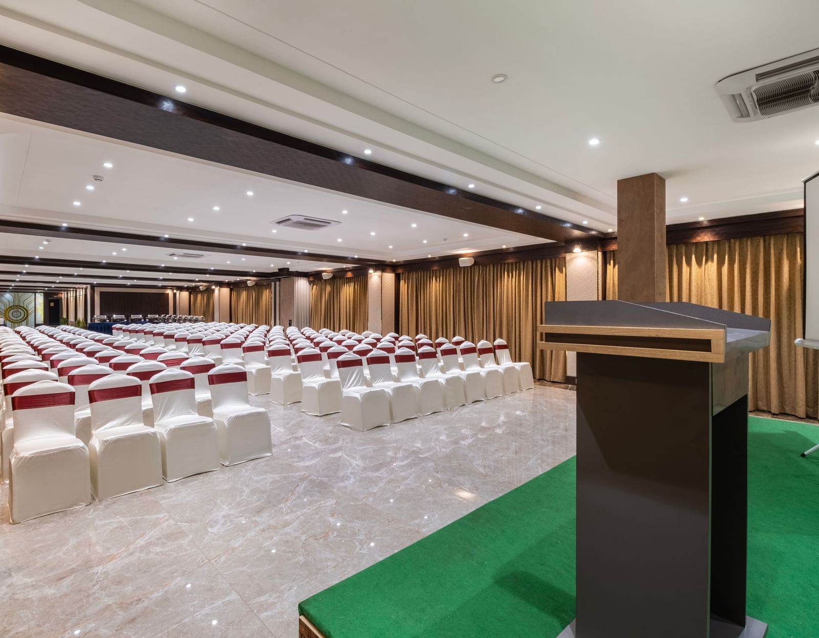 Conference hall at Monday Hotels Amalapuram Heights set with podium and theatre style seating.