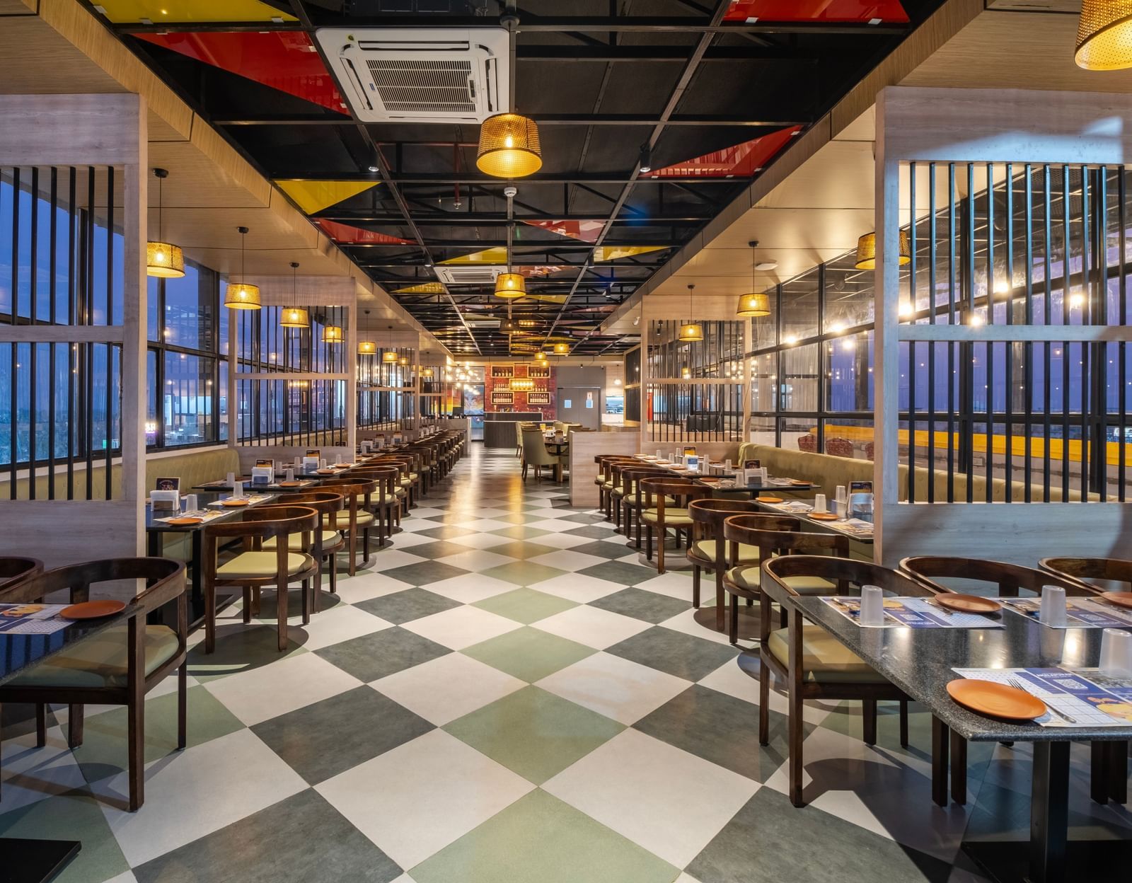 Spacious restaurant at Monday Hotels Amalapuram Heights with modern interiors and a city view.