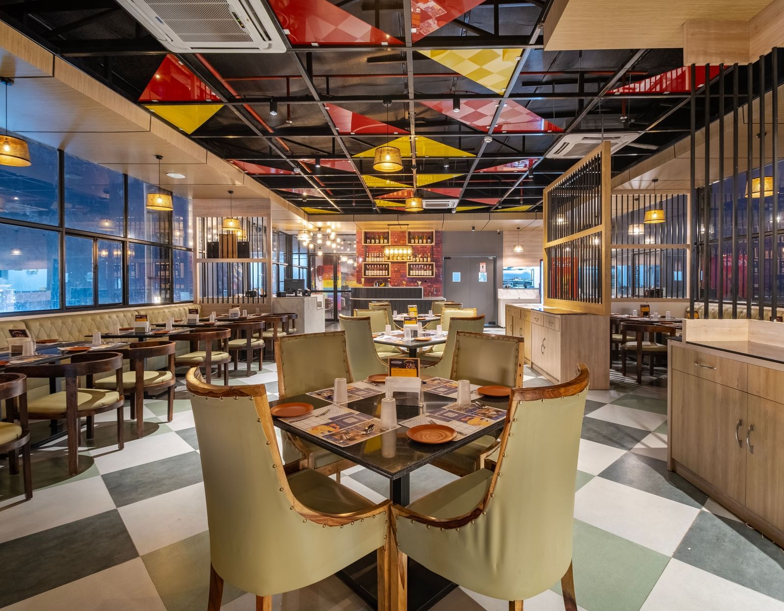 Dining space at Monday Hotels Amalapuram Heights with elegant seating, colourful seating, and city views.