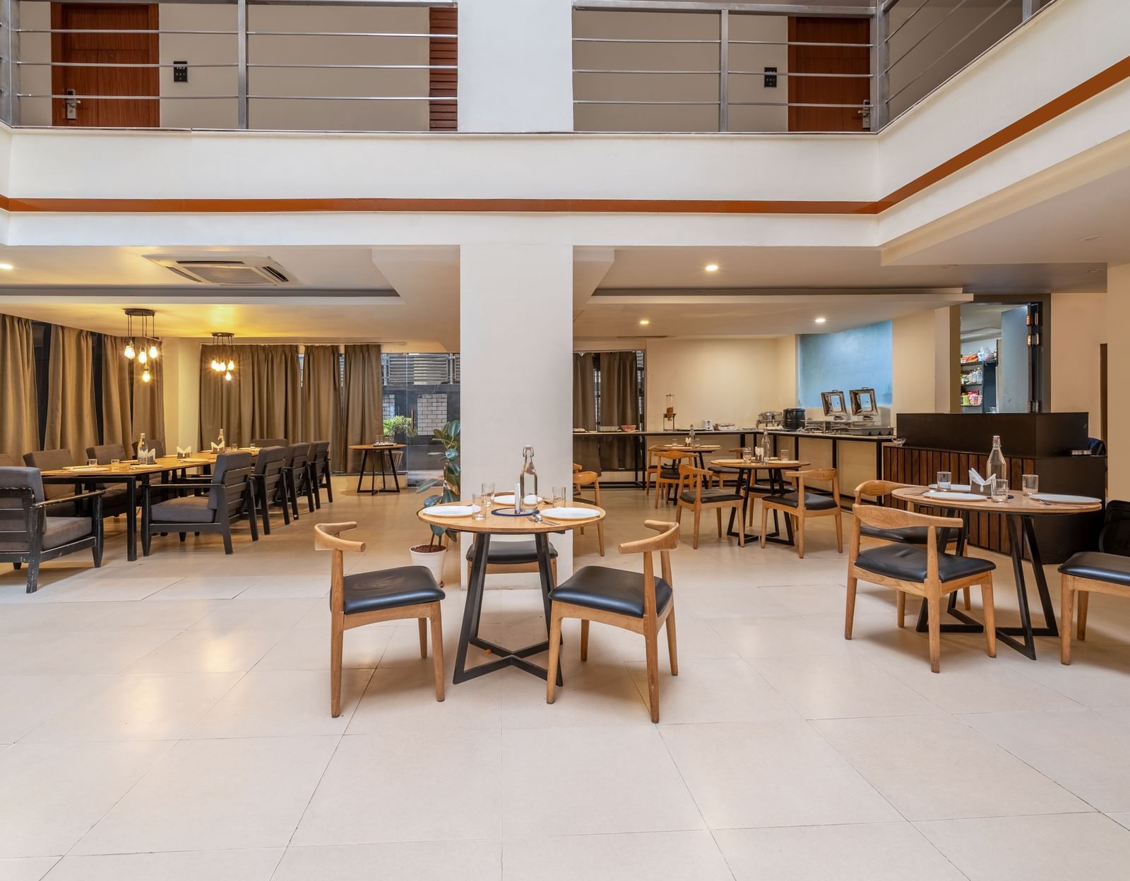 A spacious dining hall with tables and chairs neatly arranged with bright lighting - Monday Hotels HITEC City, Hyderabad