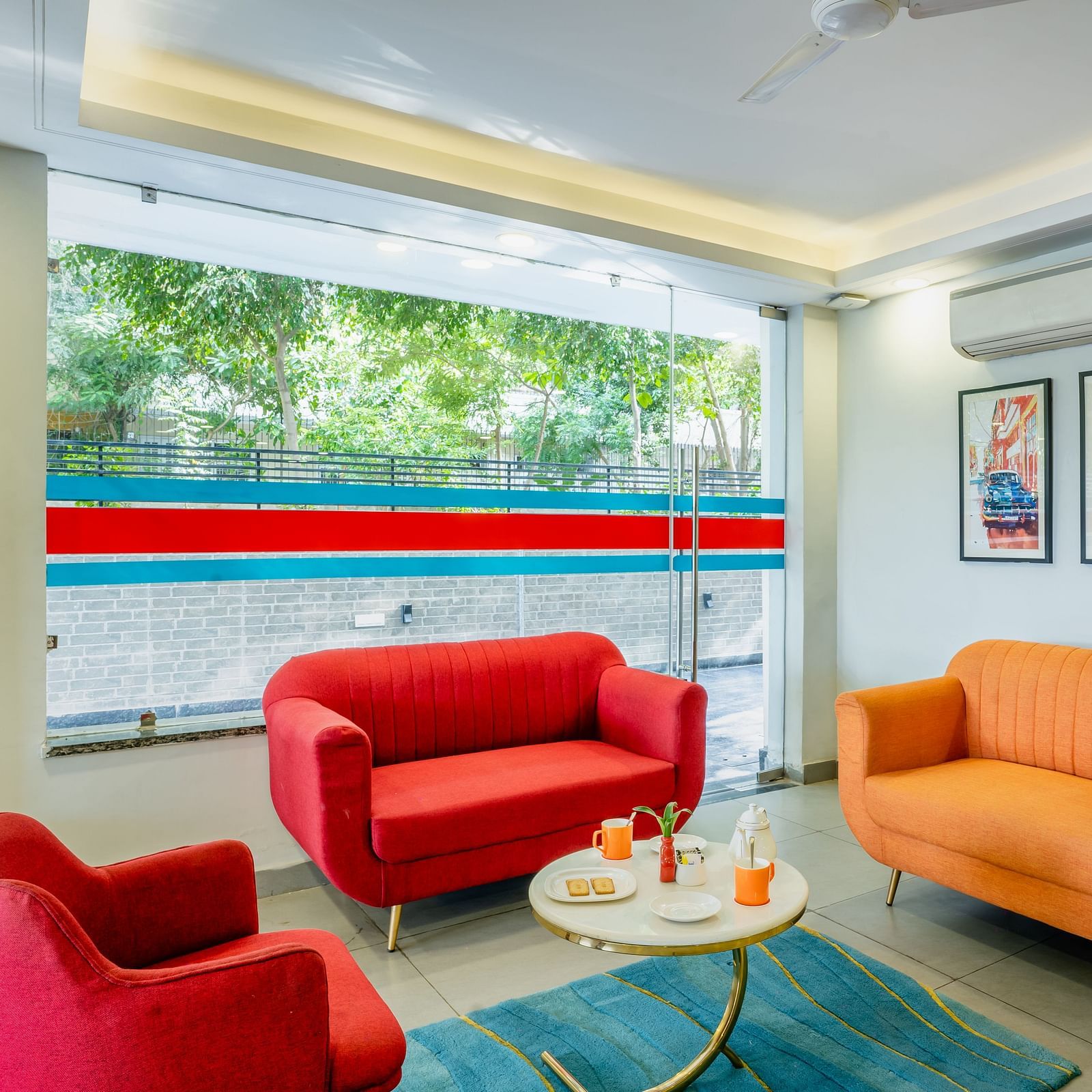 An image of a sitting area where three sofas and a centre table is placed | Inde Hotel Golf Course Extension