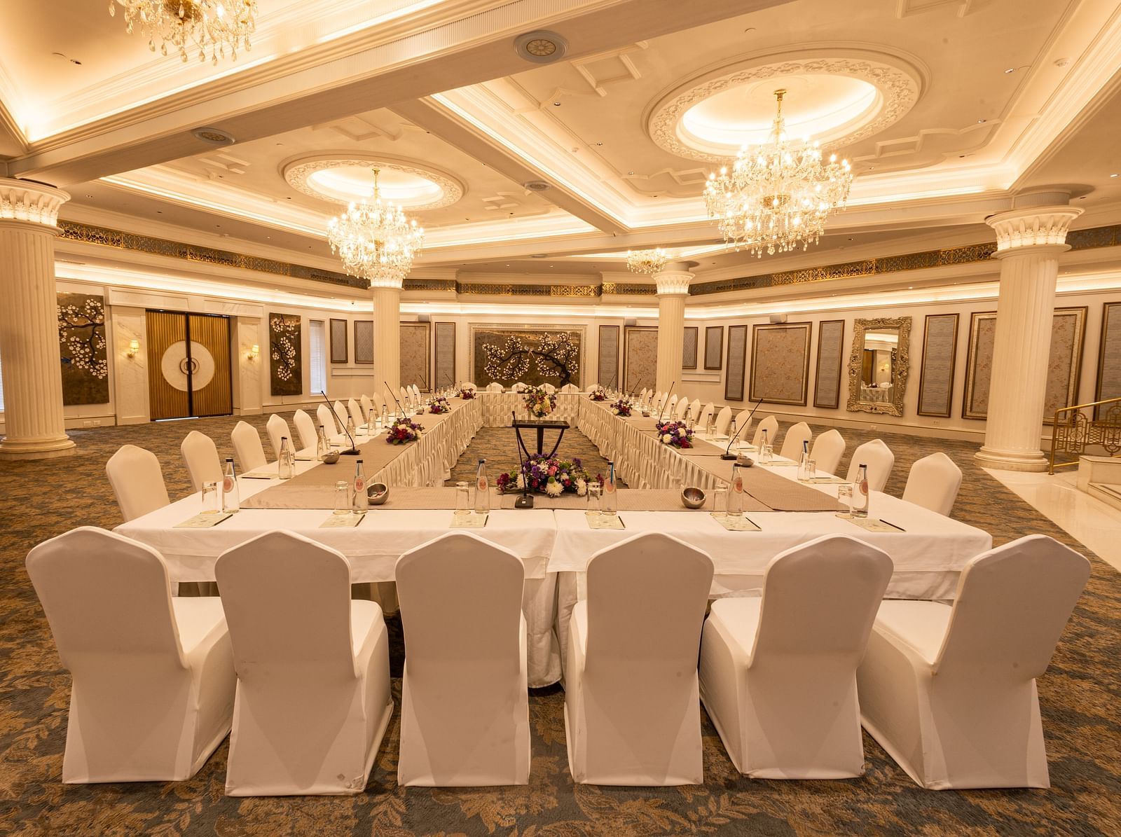 Image featuring the Viceroy Hall event venue at The Claridges New Delhi, showcasing seating arrangements and an elegant chandelier hanging overhead
