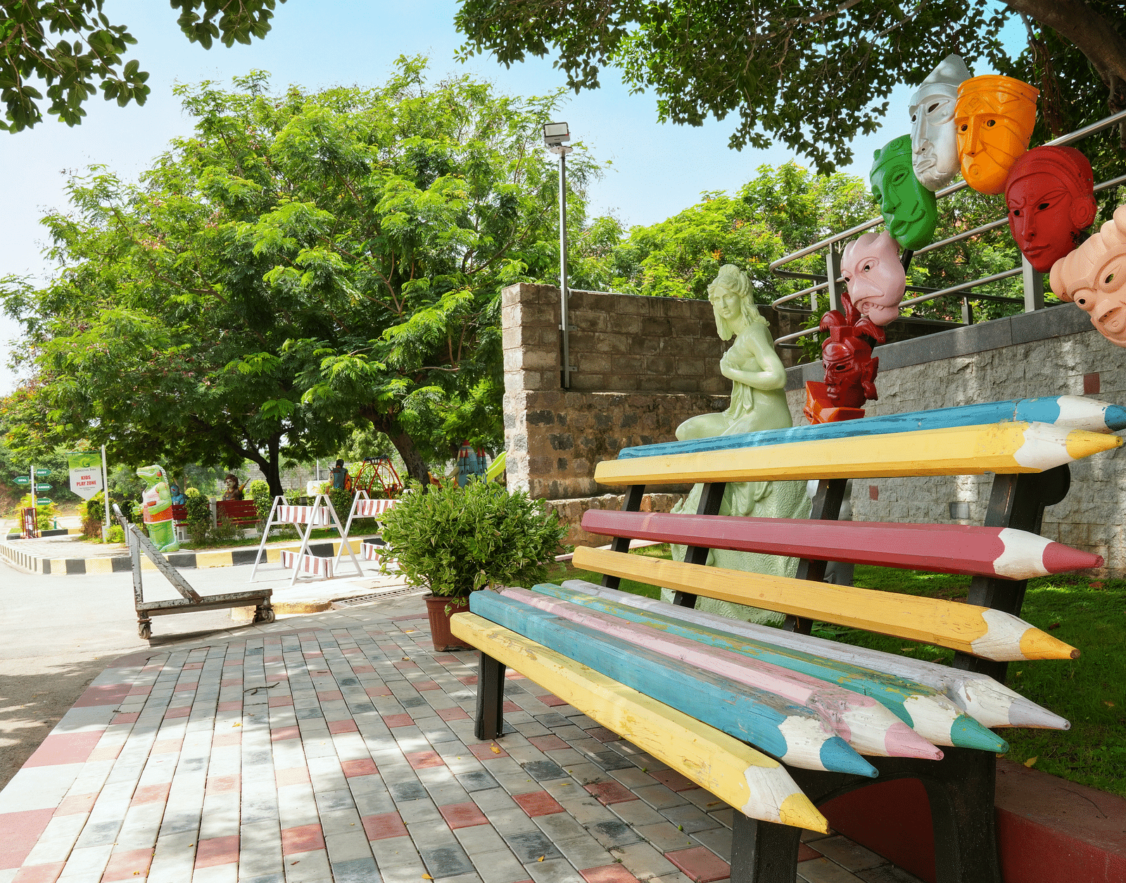 Pencil-shaped seats surrounded by trees at Greens Inn - Creative Seating in Hyderabad.