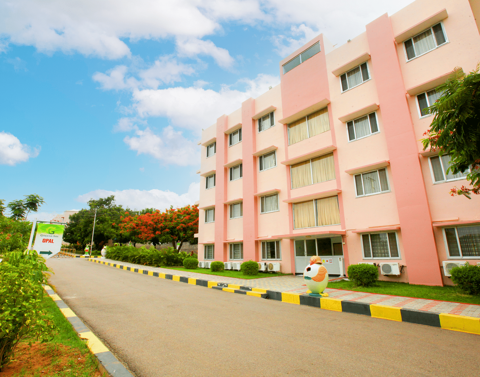 Facade of Greens Inn encircled by trees - Nature-Friendly Hotel in Hyderabad.