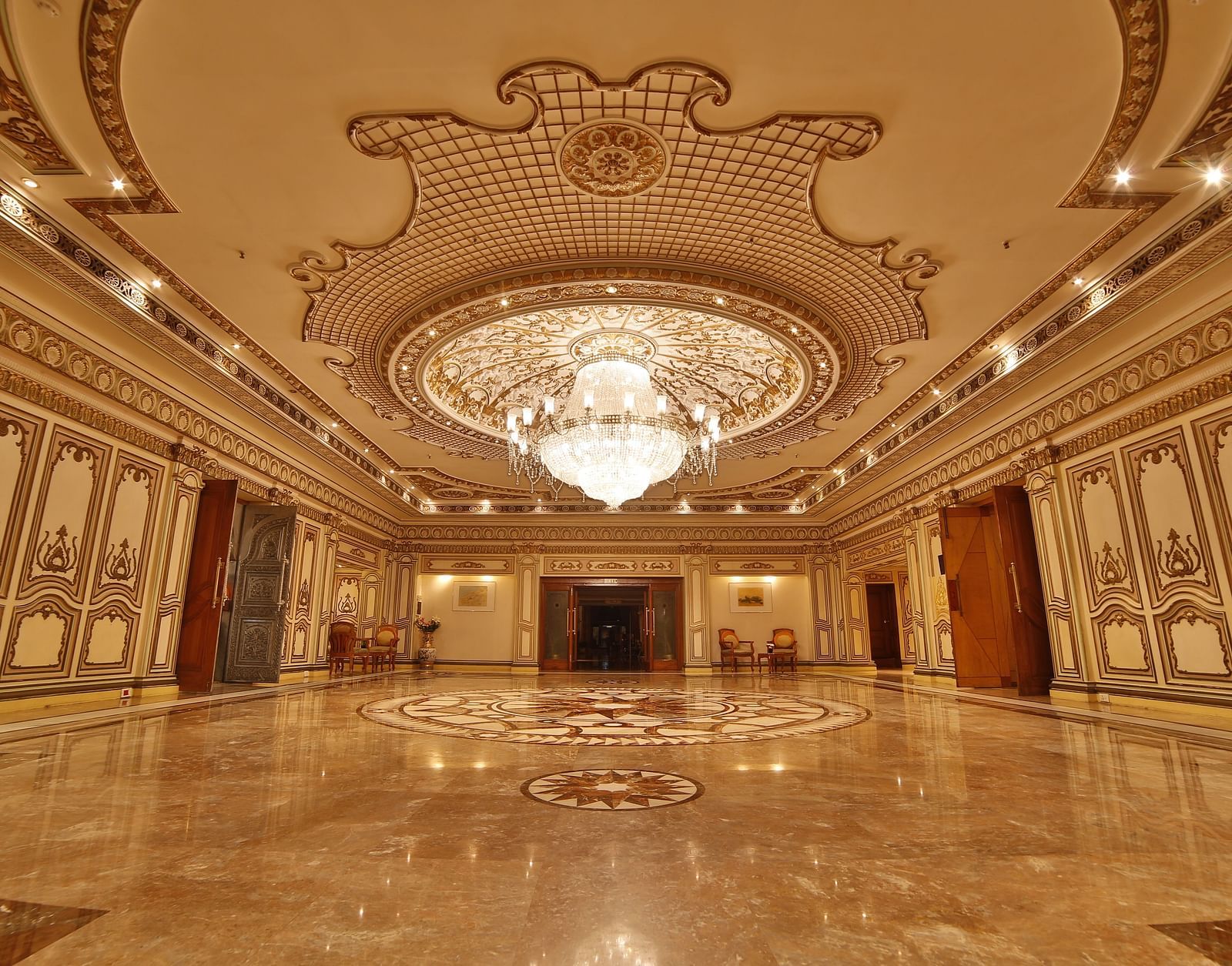  Interiors of Rang Mahal hall A grand hotel suite with an opulent red and white decor, large bed, and seating area, reflecting a traditional style at Sitara Luxury Hotel in Hyderabad near Ramoji Film City.