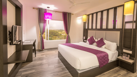 One of our bright and inviting family rooms in Palani exuding comfort, with a cosy double bed, soft linens, and warm lighting | Regency Palani by GRT Hotels