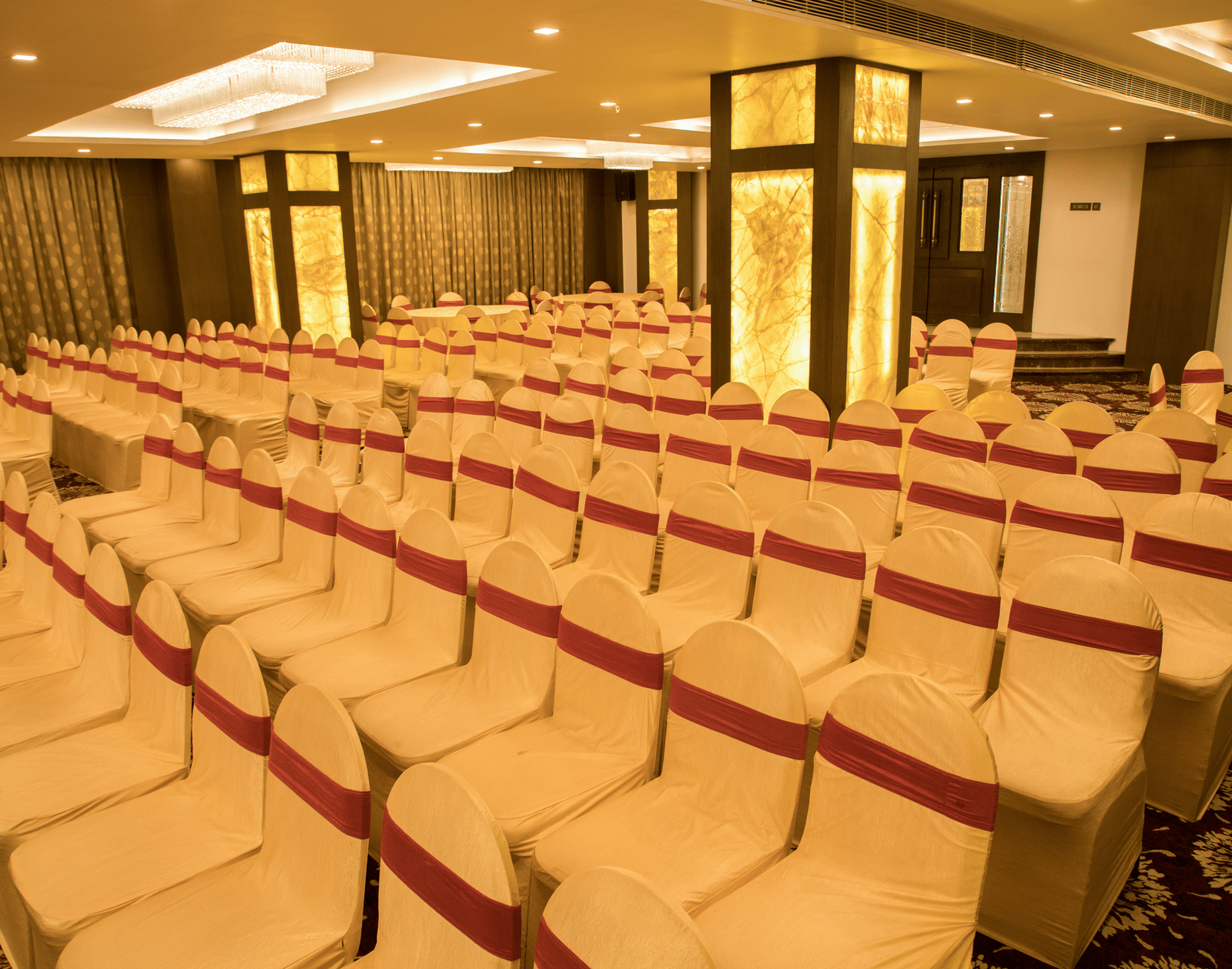 A spacious event hall at Benzz Park Chennai filled with neat rows of chairs, ready for a large gathering or conference.