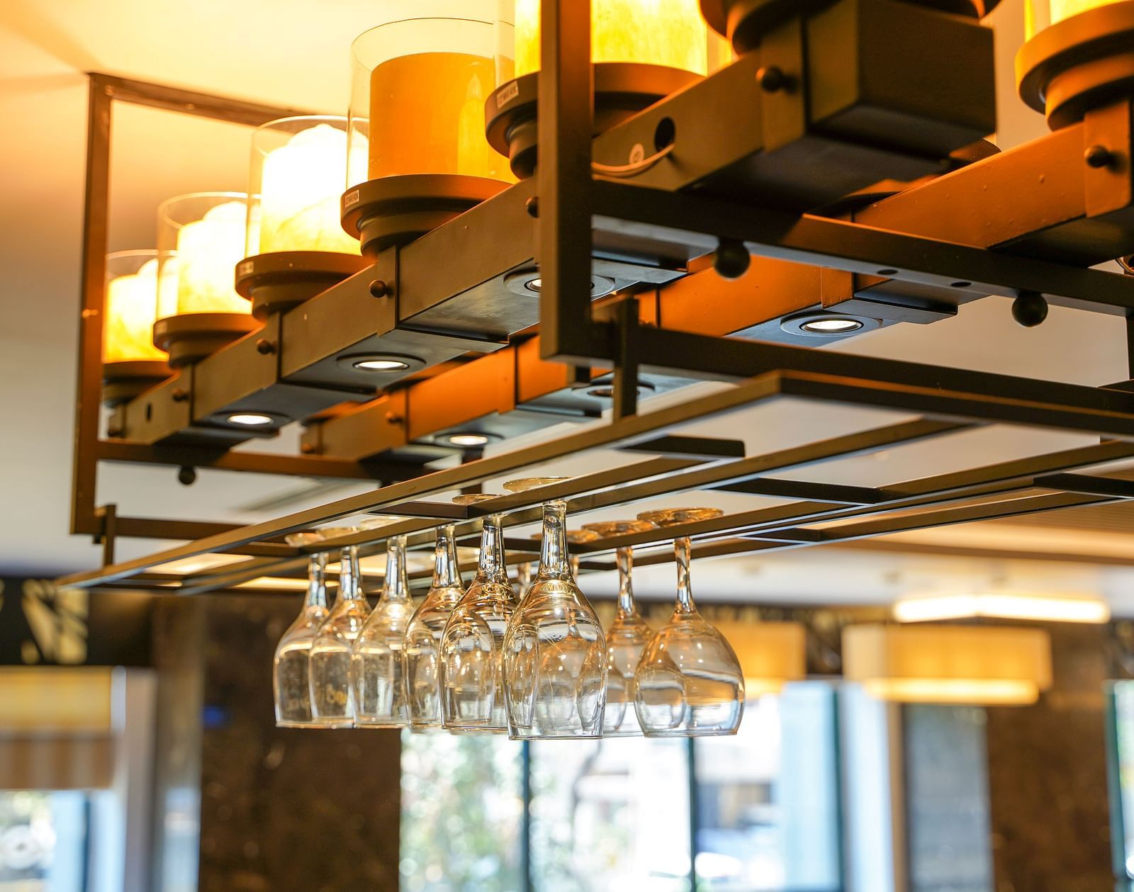 An upscale lounge space within BNGV Grandeur Hotel Banquets, featuring square tables and plush seating, under ambient lighting.