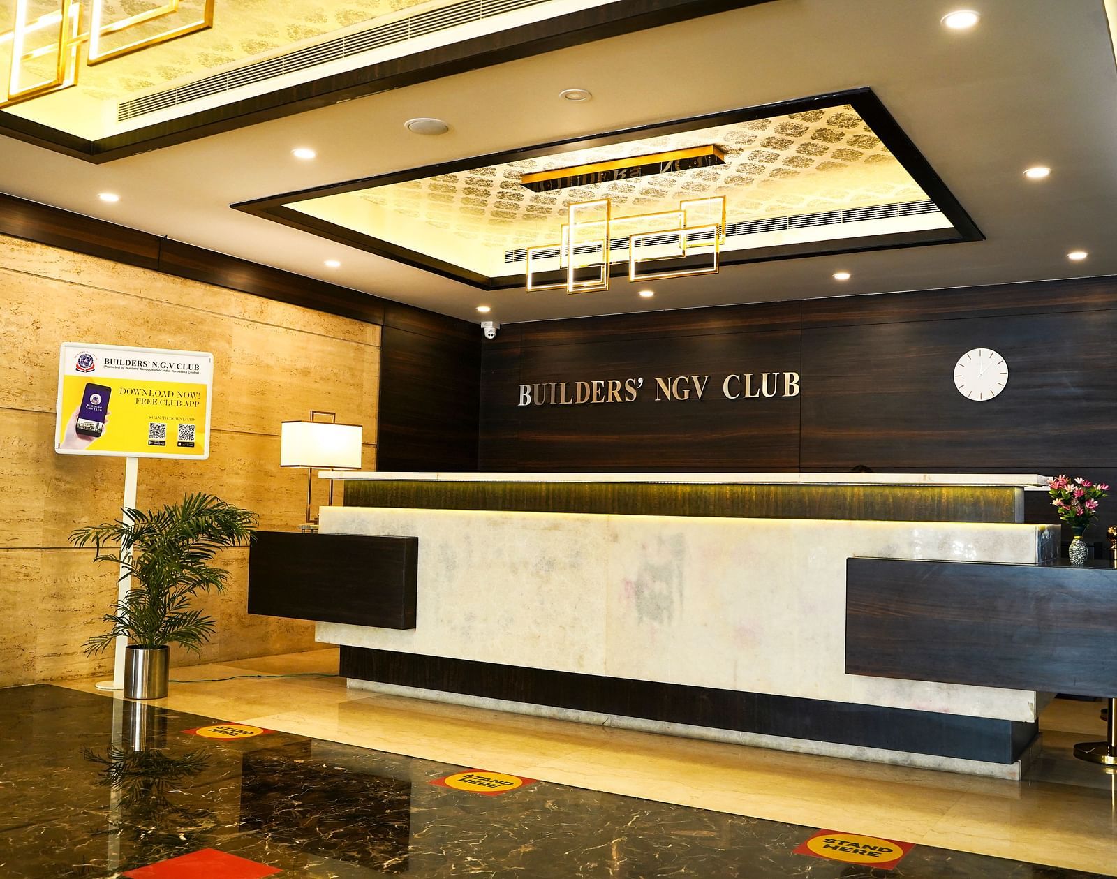 The modern reception counter of the hotel lobby at BNGV Grandeur Hotel and Banquets, with elegant lighting and dark accents.