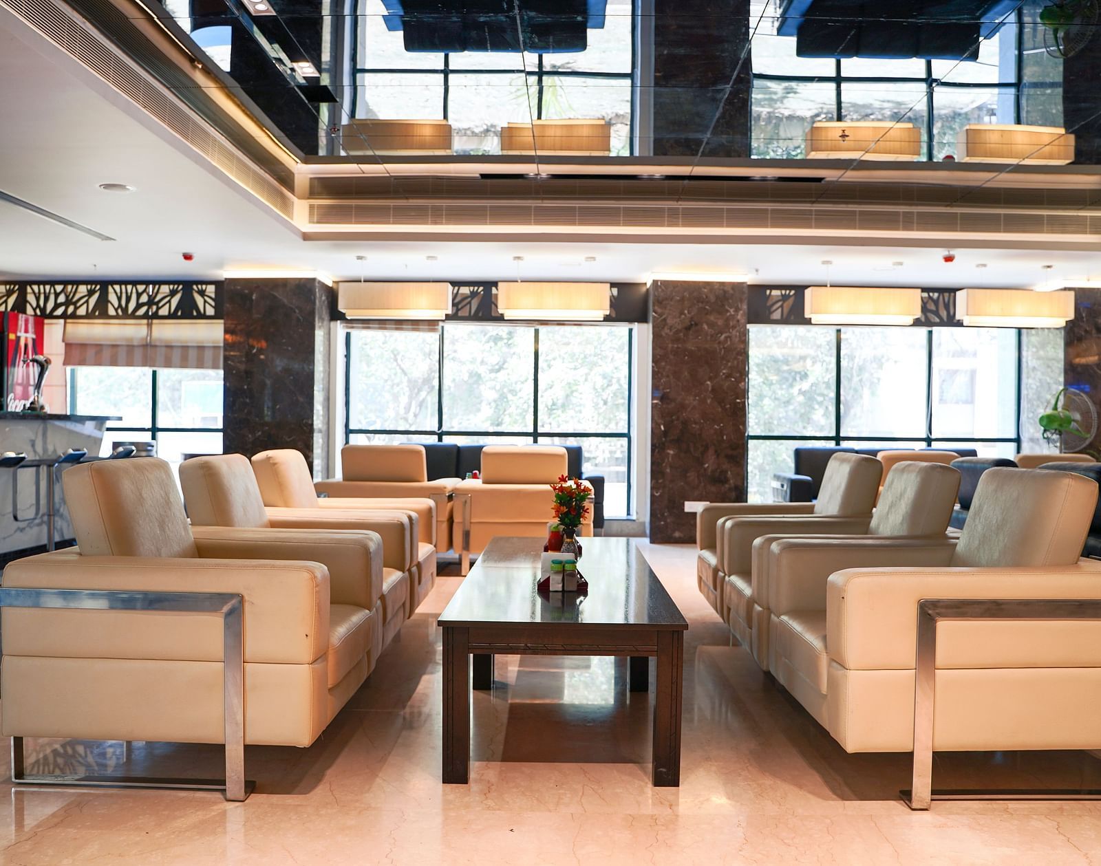 A stylish lounge area with light-colored sofas and coffee tables, reflecting modern interior design at BNGV Grandeur Hotel and Banquets.