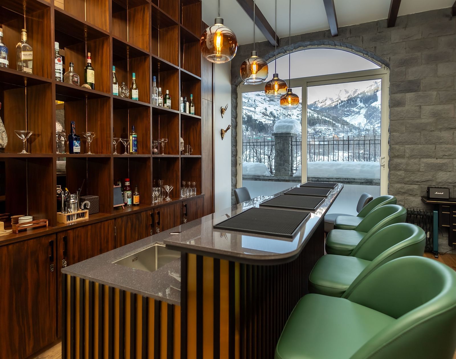 Intimate bar nook with wooden shelves and plush seating at Nivasana Manali.