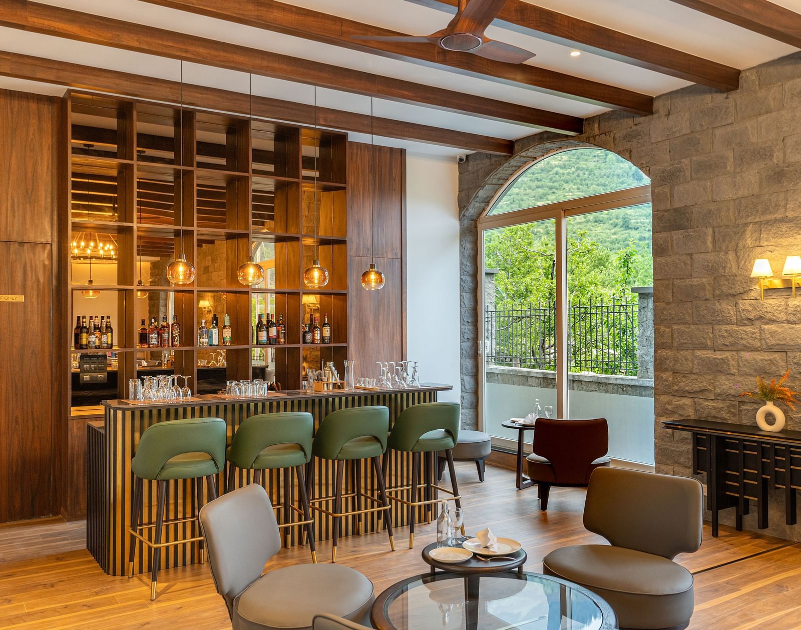 Elegant bar space with large windows and comfy seating at Nivasana Manali.