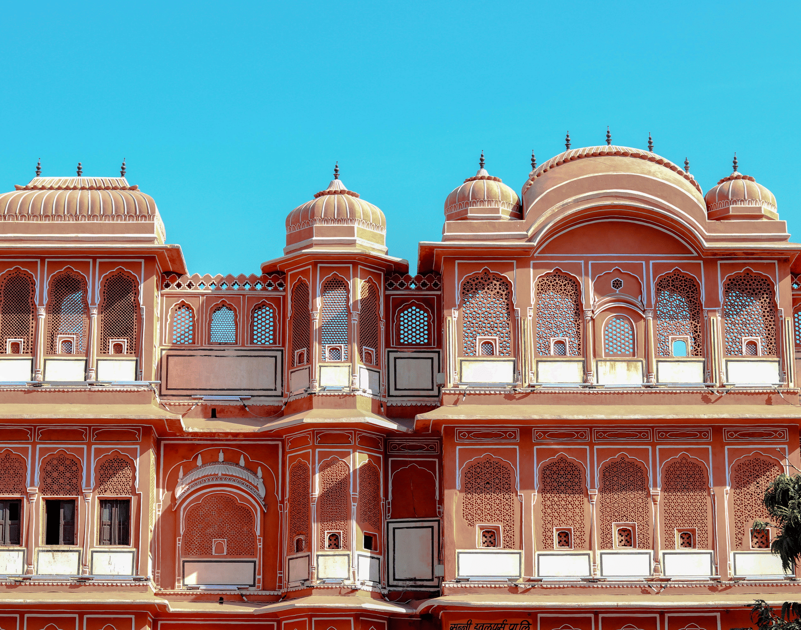 Vibrant red palace facade with arched windows and decorative balconies.