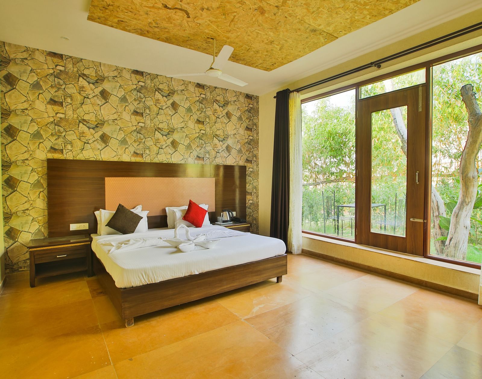 A room with a bed and a large glass wall and door on the side at Valley by Grassfield.