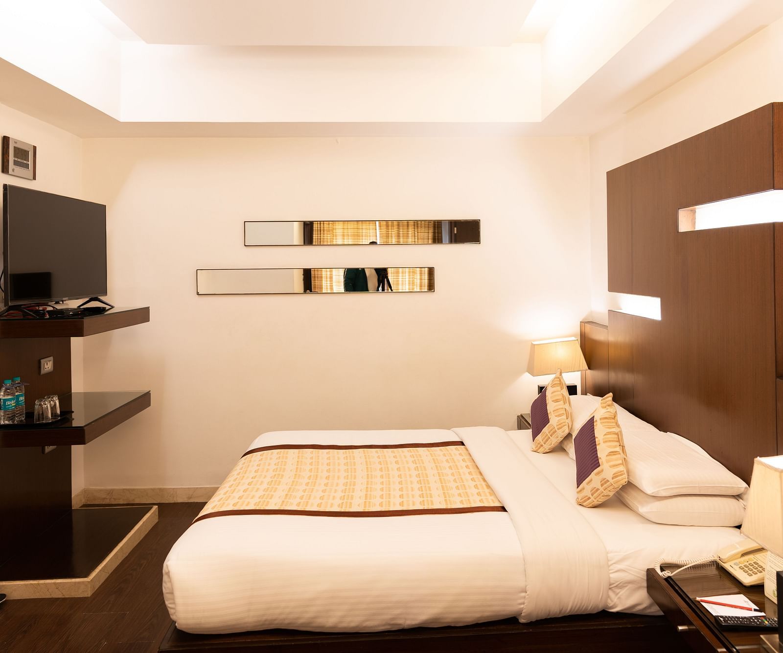 A warm and inviting hotel room with soft lighting and a comfortable bed at The President Hotel, Jayanagar
