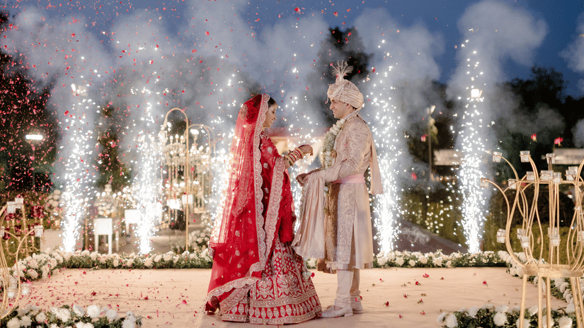 Bride and groom making a grand entrance with fireworks during a night wedding at Umaid Palace.