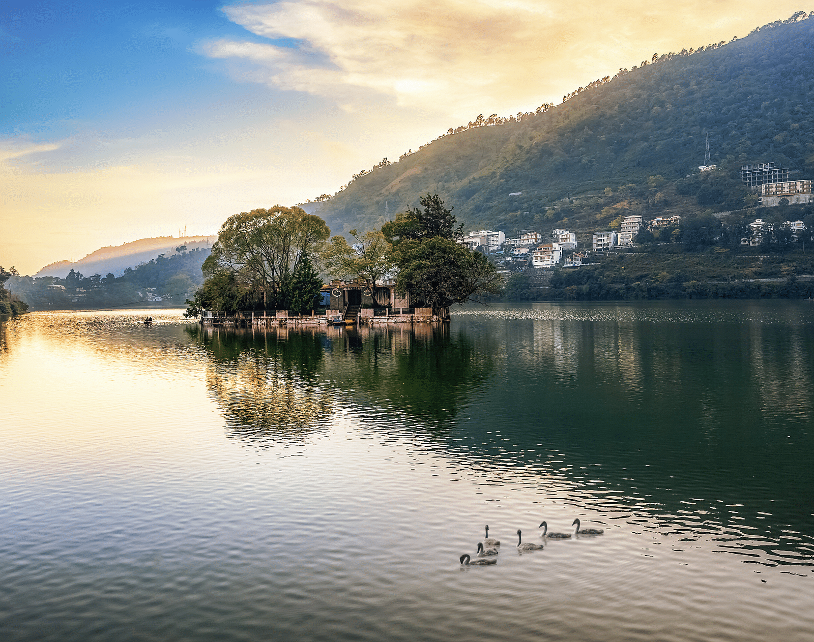 A picture featuring Lake at sunset with mountains reflected in the water.