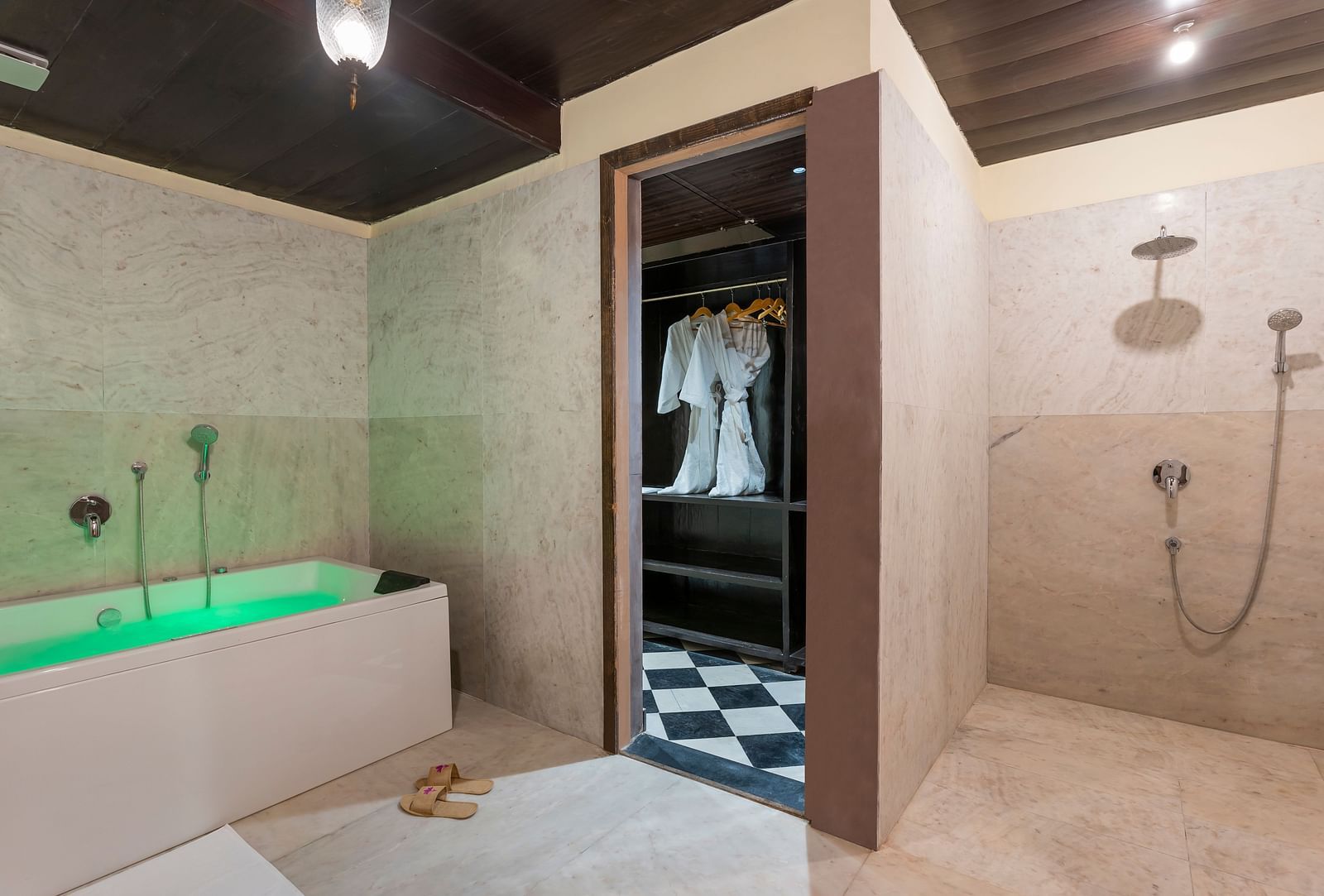 Luxurious bathroom with green bathtub, open closet, and rain shower at Kesar Bagh Palace.