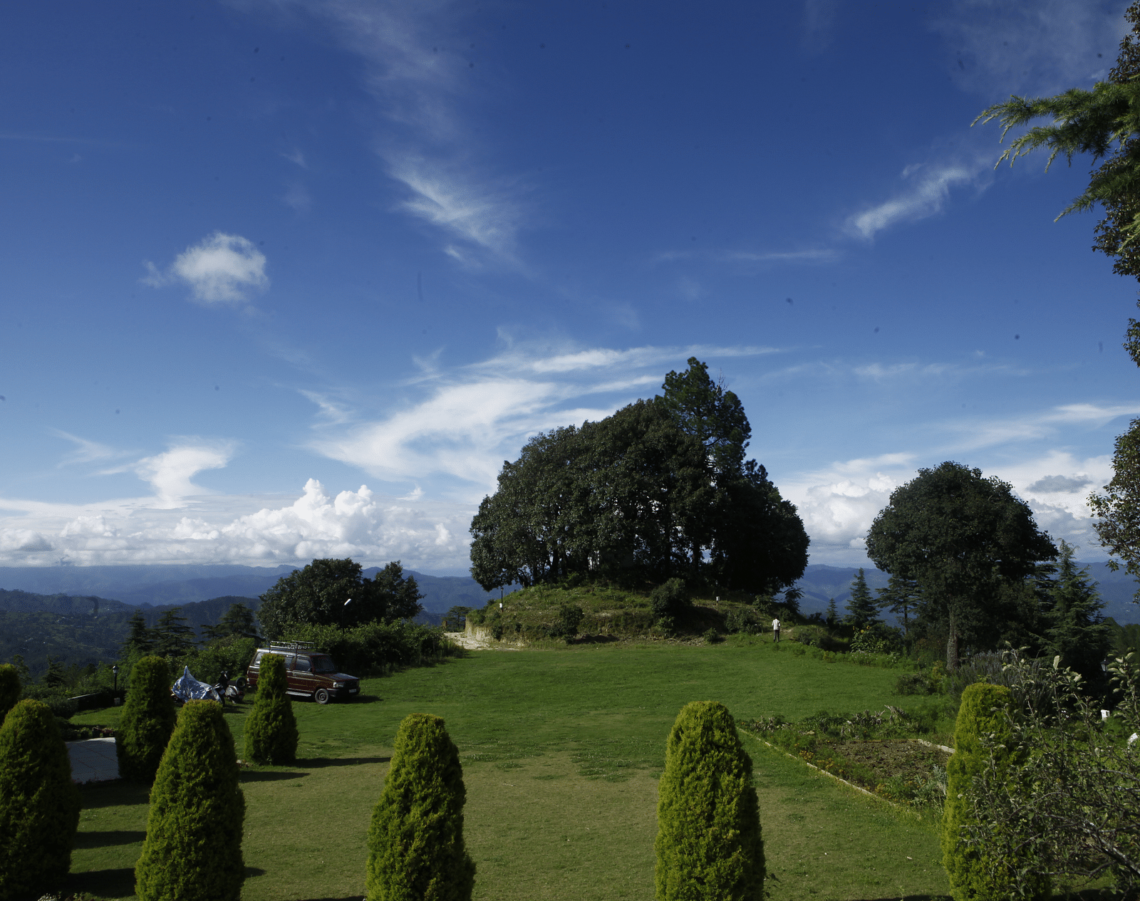 A vibrant wedding lawn in Almora with a scenic backdrop of hills and trees - BluSalzz Escapade - Anant Rasa Resort