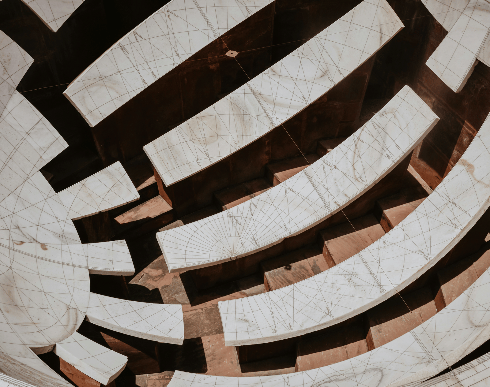 Curved marble instruments of Jantar Mantar observatory showing geometric lines and astronomical markings used for measuring time and celestial positions