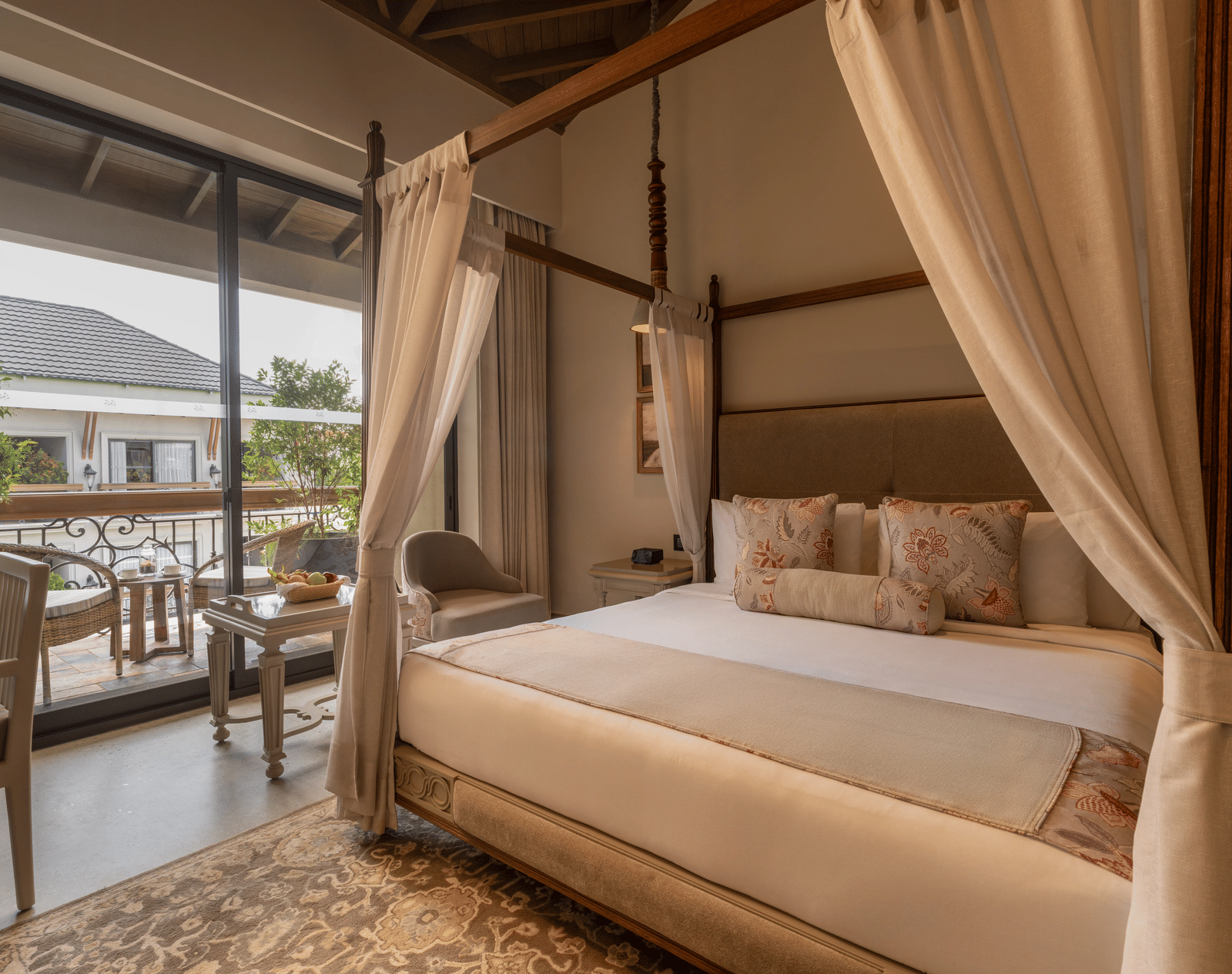 A plush bed in the Premium Room at The Evren, Vagator, with a balcony beside it featuring a sit-out area.