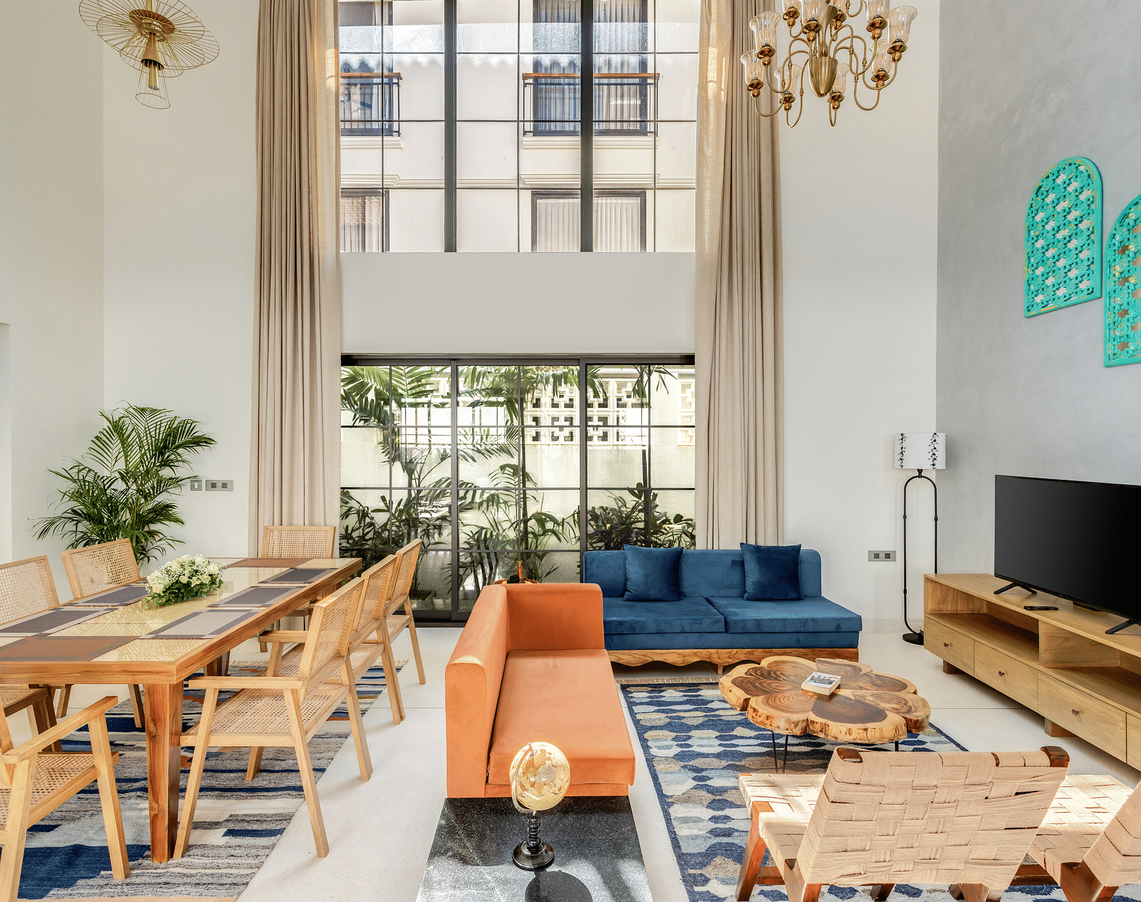 A spacious living and dining room with high ceilings, contemporary furnishings, and large windows flooding the space with natural light - BluSalzz Villas - Alocassia, Anjuna