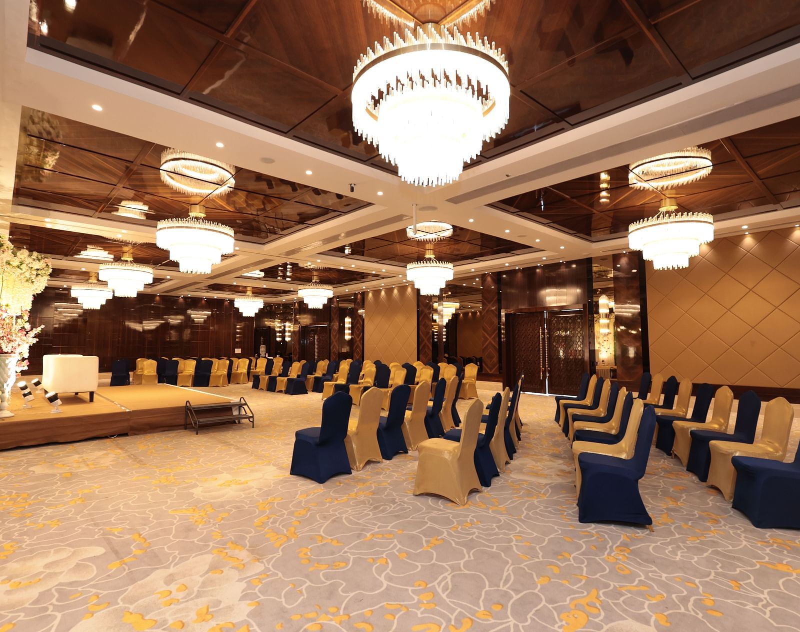 A side view of a banquet hall with chairs arranged around the stage area | Cenneys Gateway