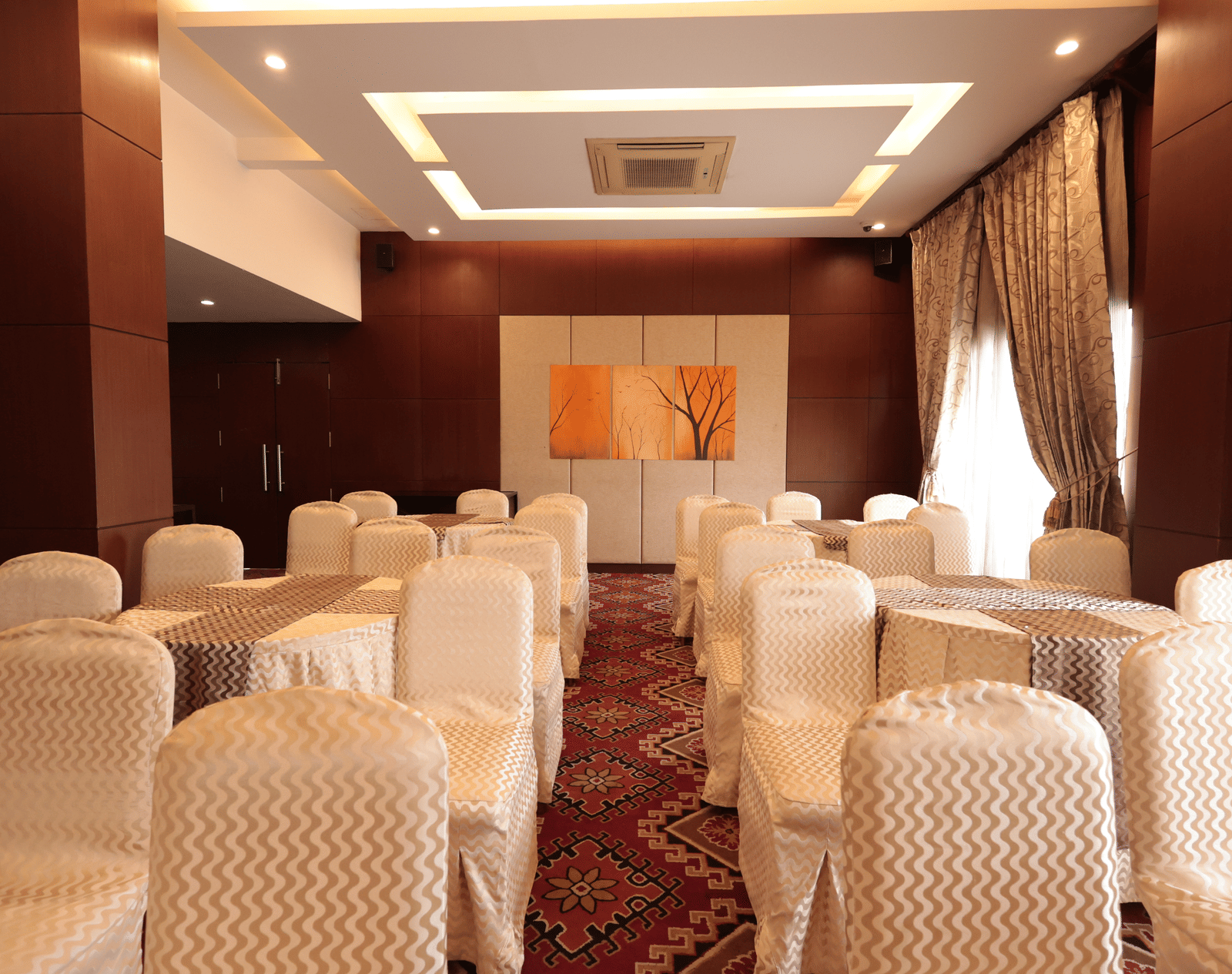 A small banquet hall with well-decorated chairs and curtains draped over the windows | Cenneys Gateway