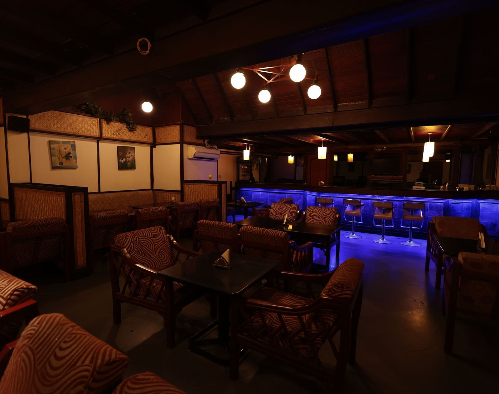 A dining area with neatly arranged tables and chairs under dim lighting | Cenneys Gateway