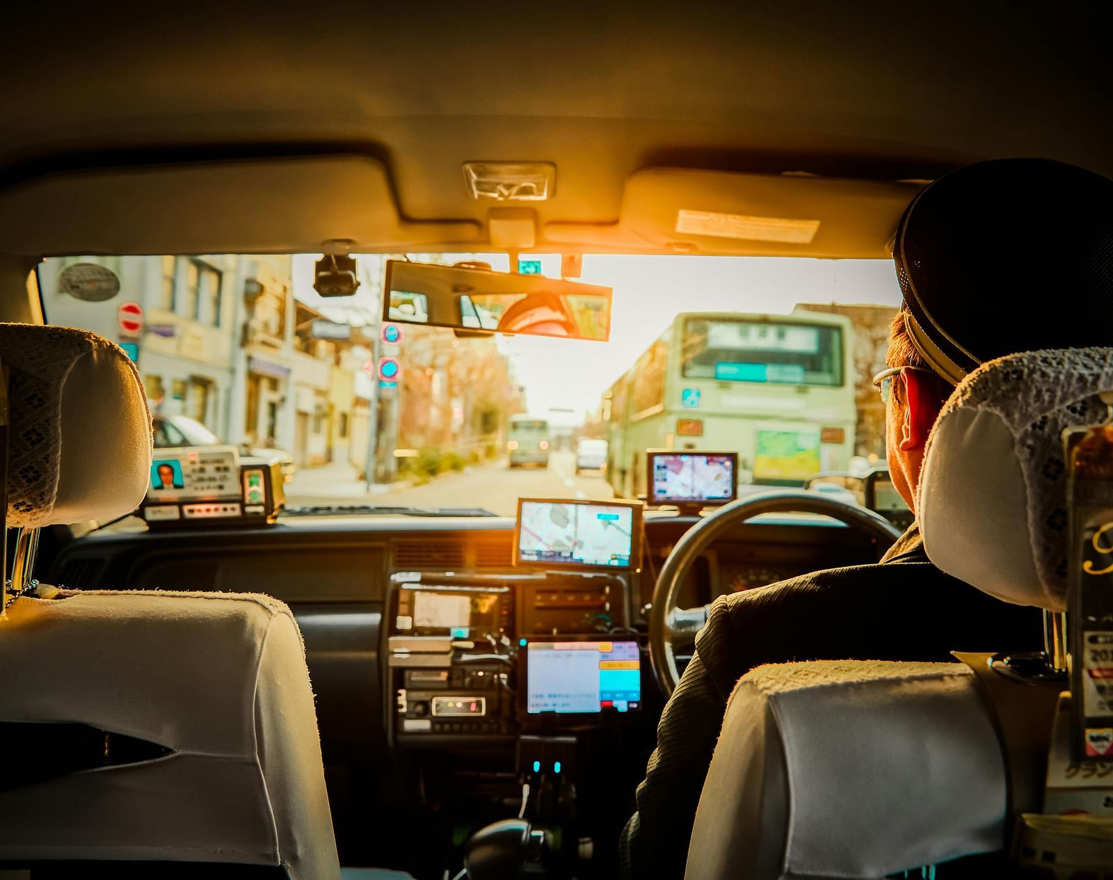 A backseat view of a person driving the car.