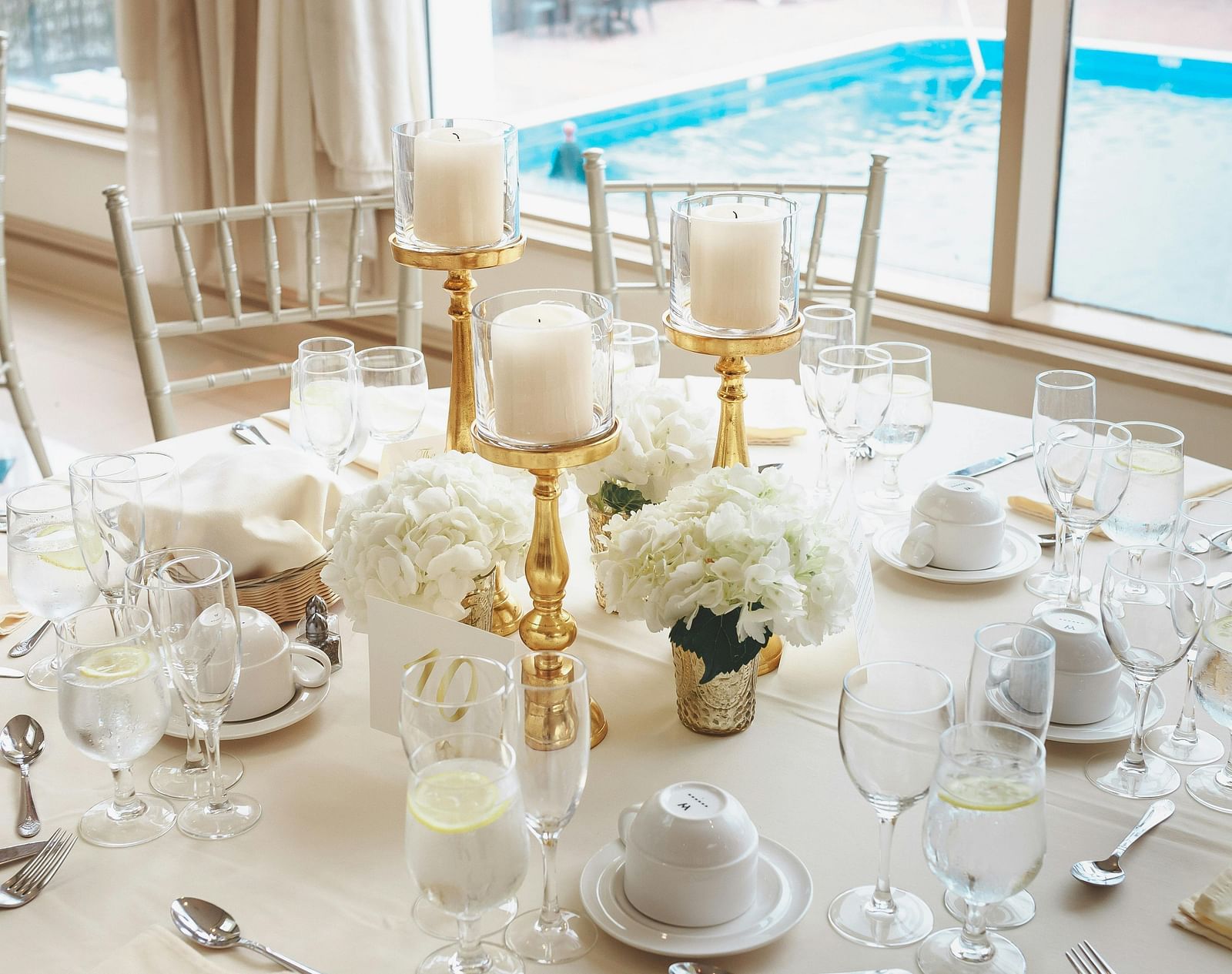 A close-up view of a neatly set table beside a pool.