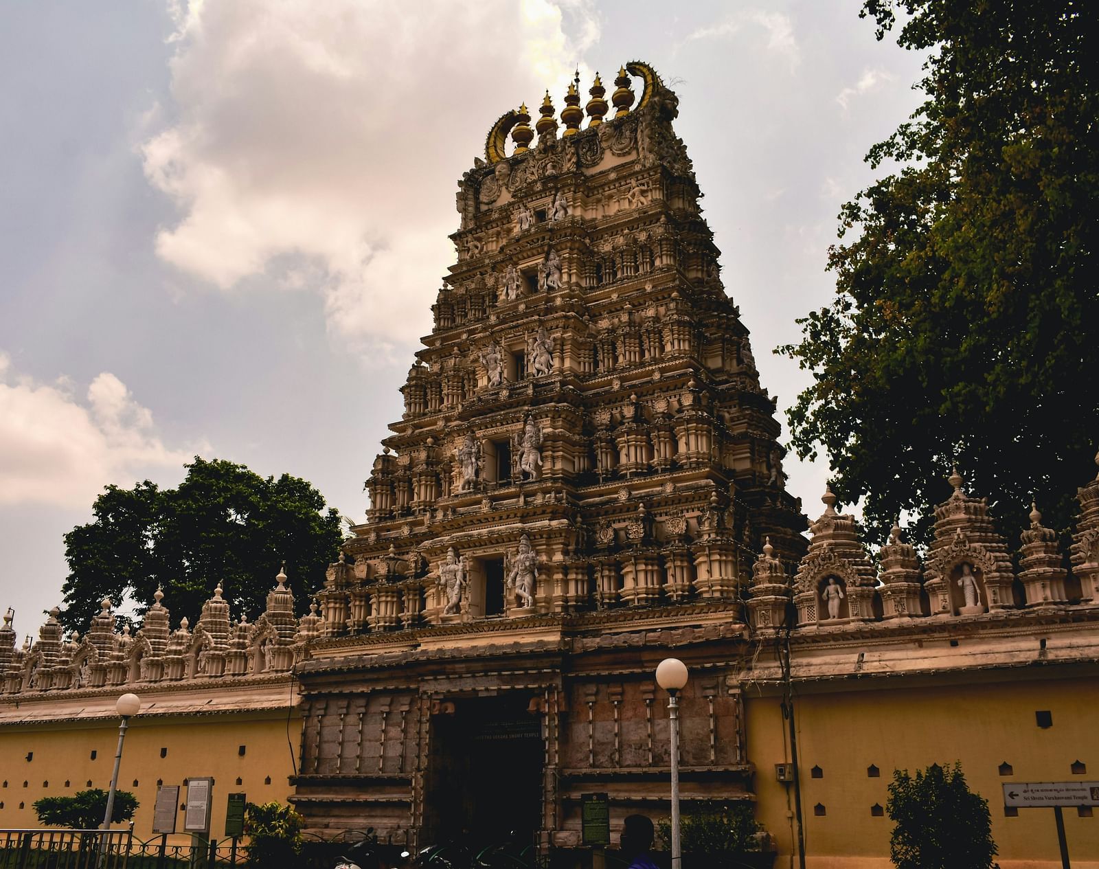An overview of a temple in the evening with intricate art on the roof of the temple.