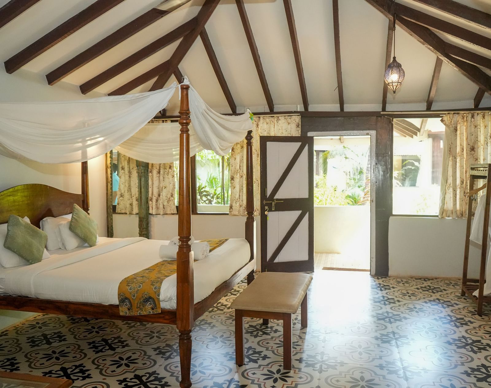 Cosy bedroom with canopy bed and large windows letting in natural light at De Soul Santé, Morjim.