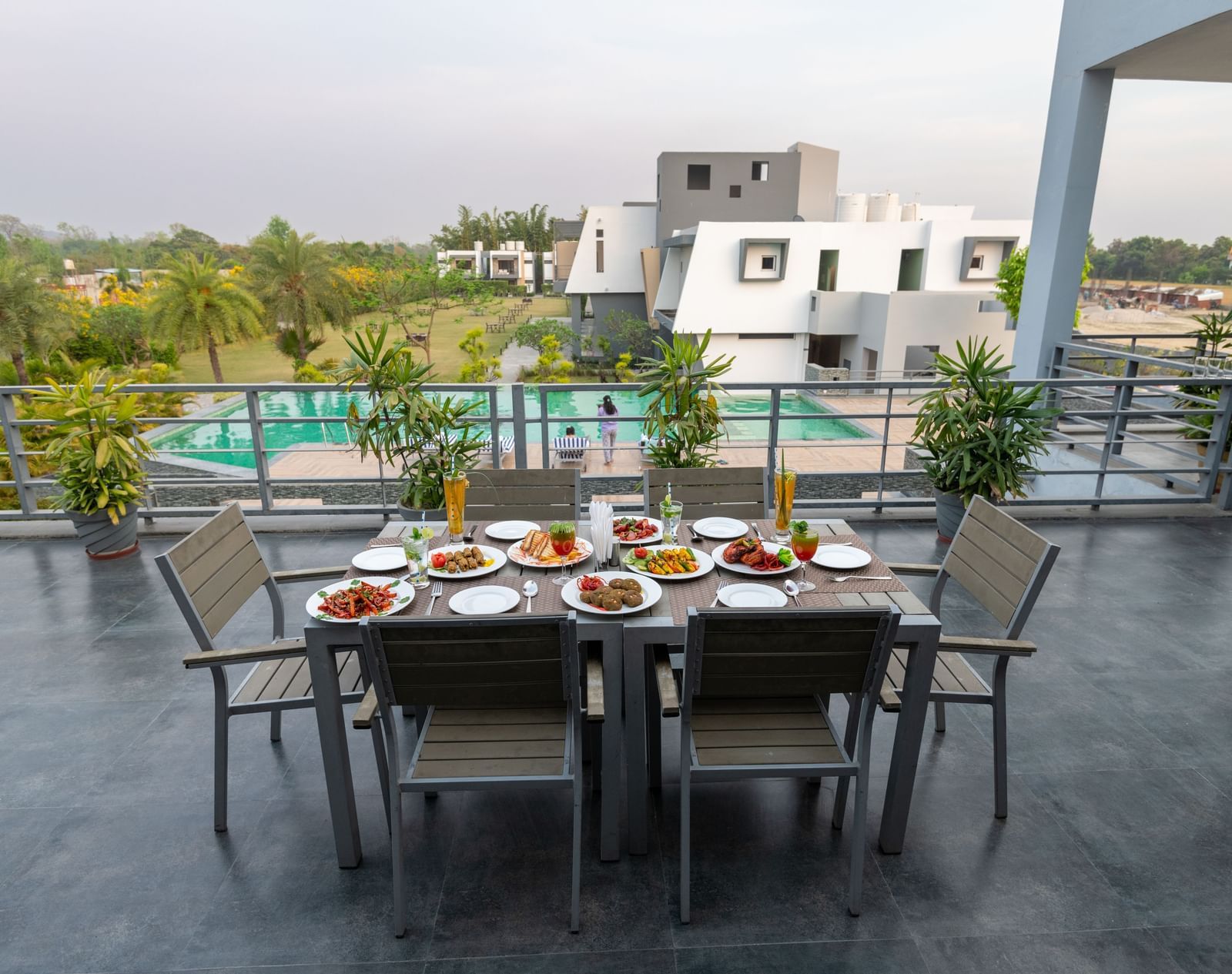 A table for six set with a variety of dishes on the terrace at DLS Forest Vines Resort.