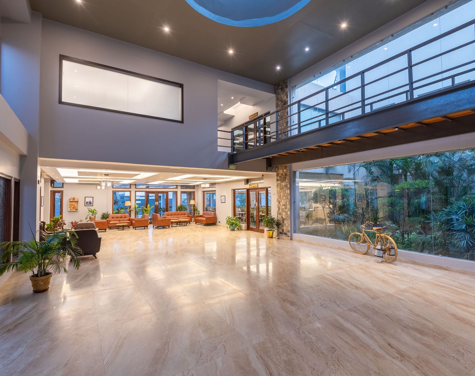 Reception area at DLS Forest Vines Resort viewed from the far end, with bright lighting and cushioned sofas.