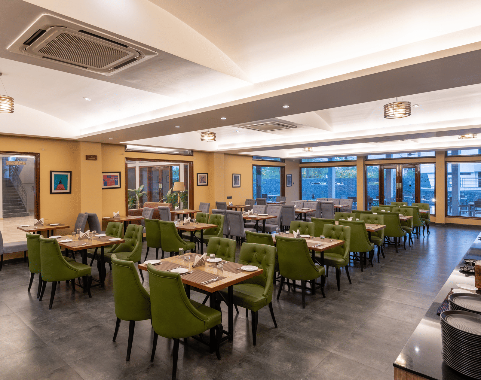 Diagonal view of the restaurant in Jim Corbett at DLS Forest Vines Resort, featuring tables and seating set for guests.