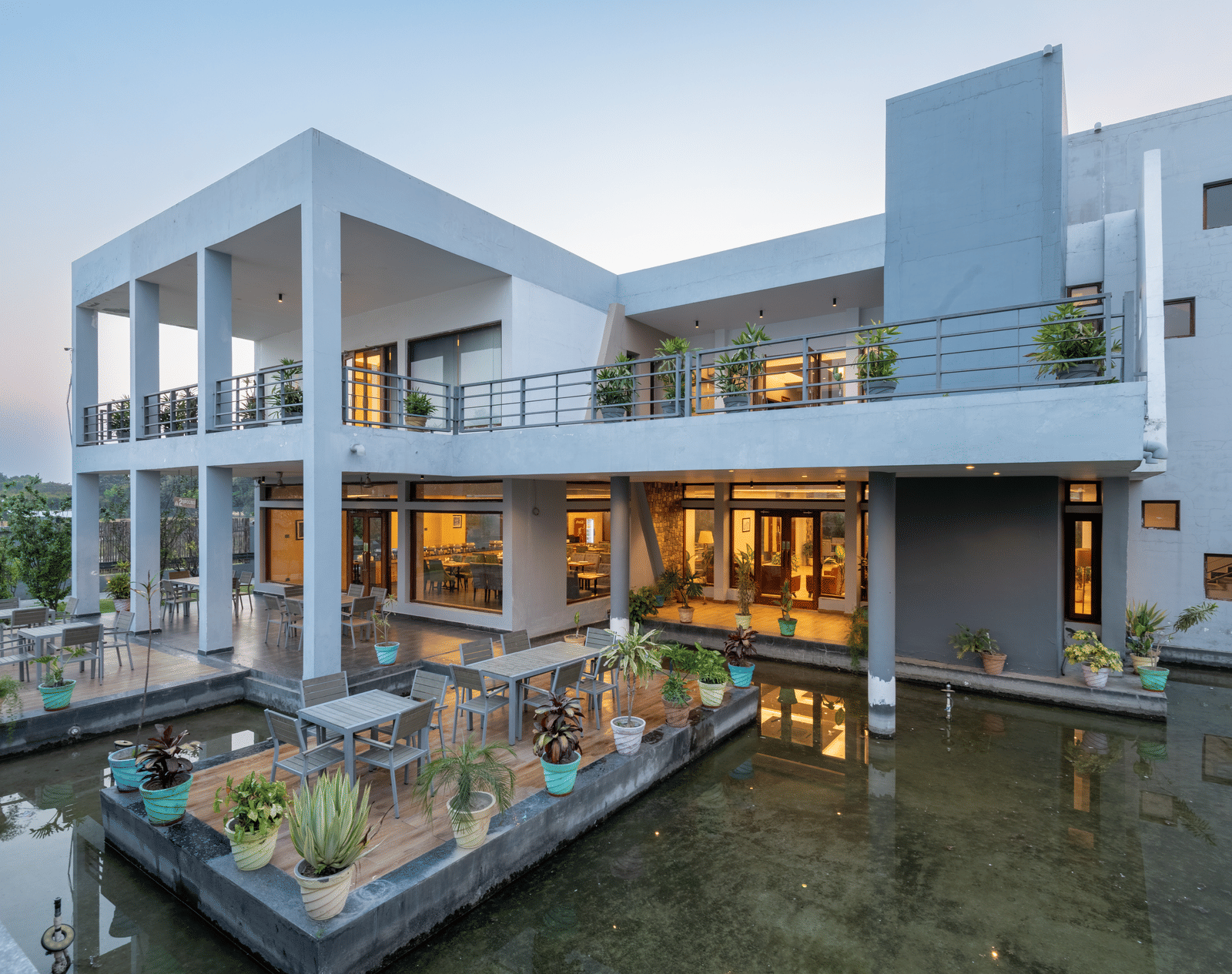 Facade view of DLS Forest Vines Resort, illuminated by warm lights from the windows and doors.
