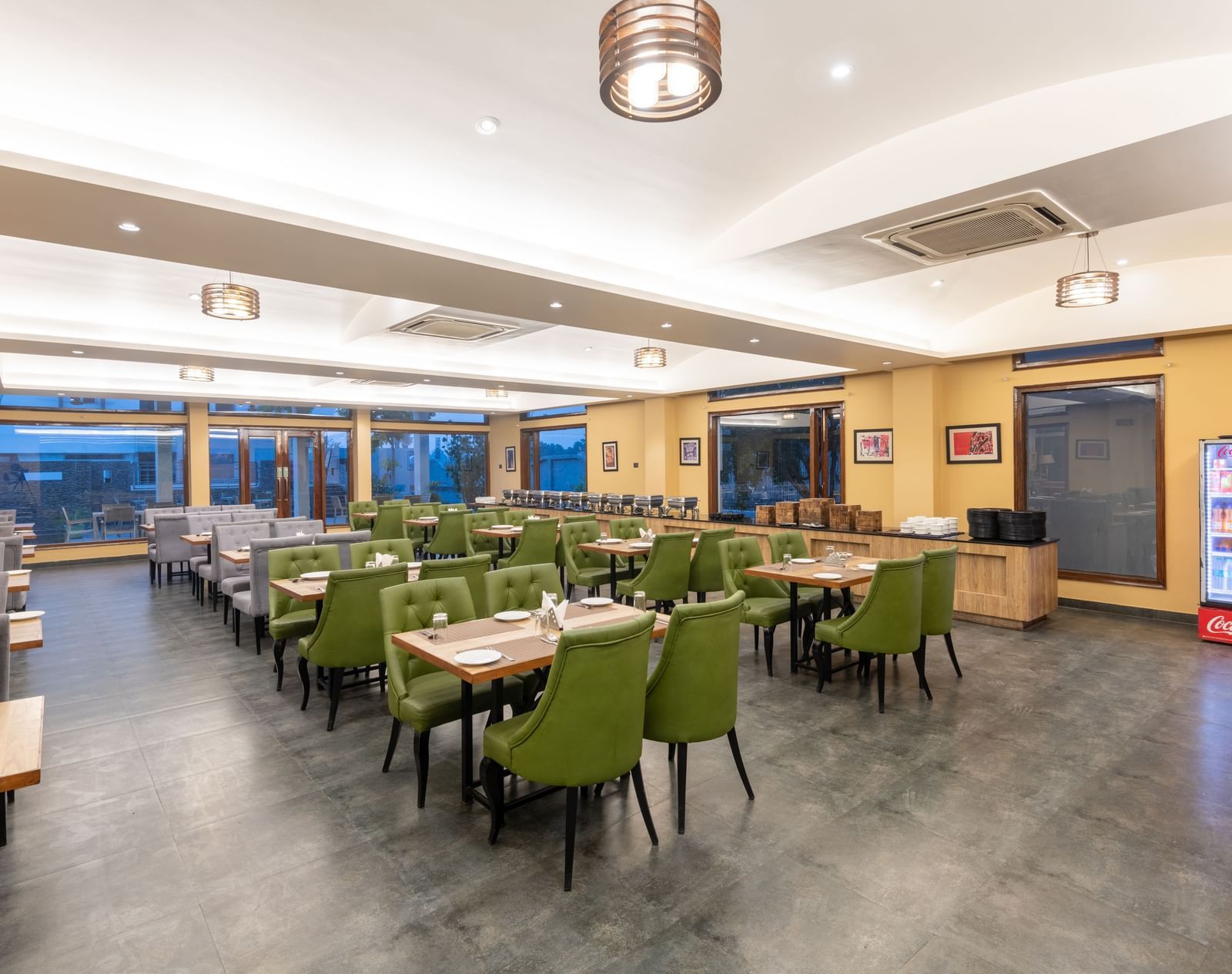 Brightly lit diagonal view of the restaurant in Jim Corbett at DLS Forest Vines Resort, showcasing tables and seating arranged for guests.