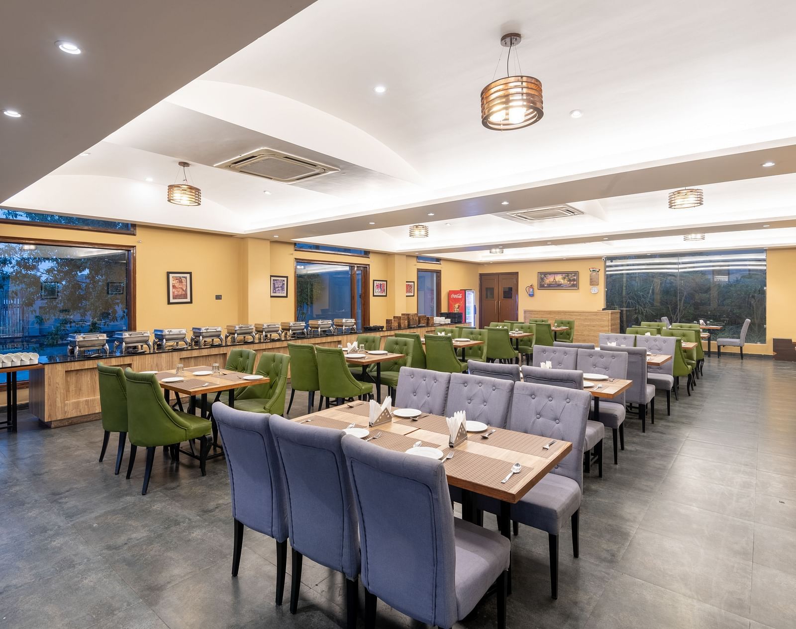 Diagonal view of the restaurant at DLS Forest Vines Resort, featuring tables and seating set for guests.
