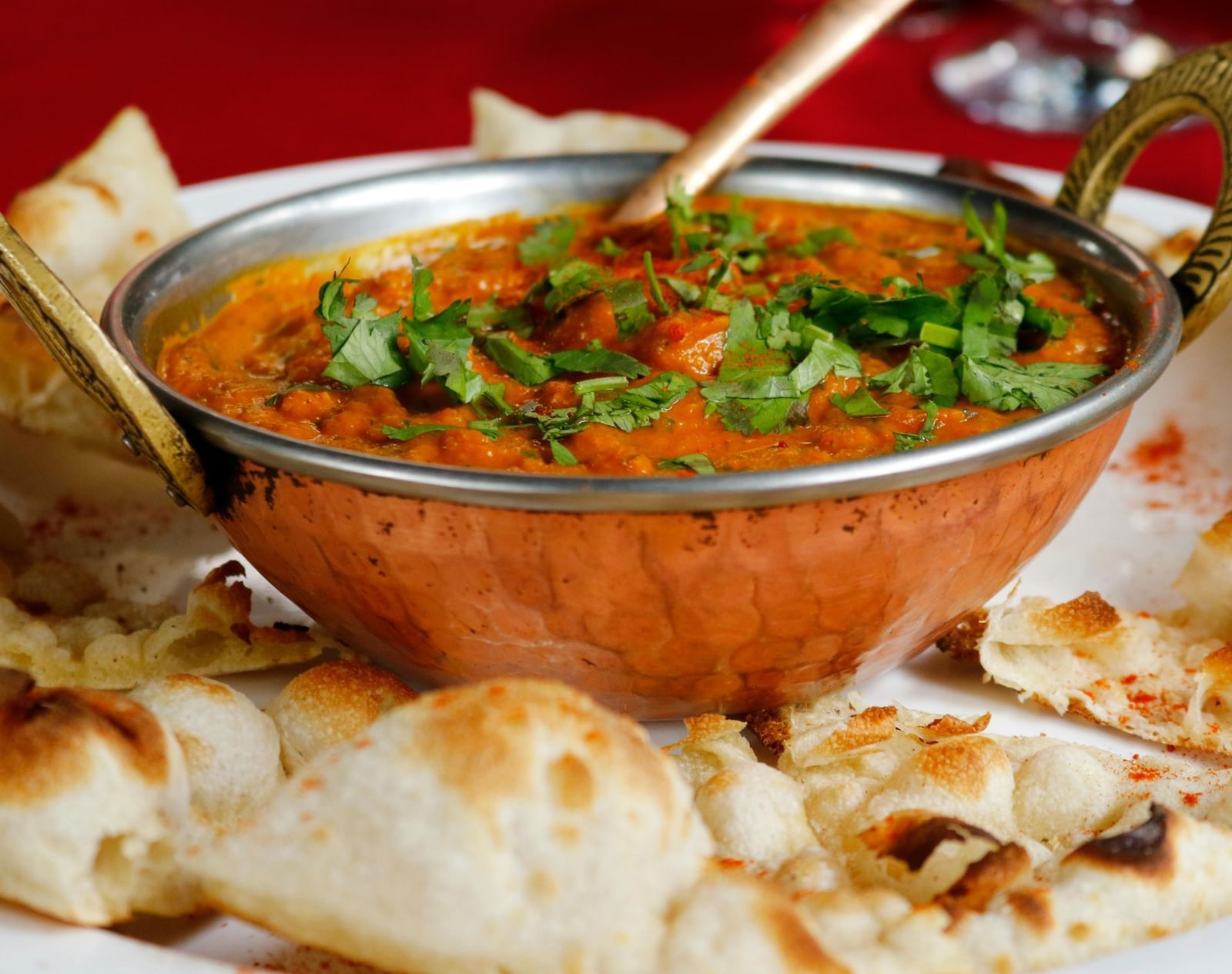A delicious Indian dish of butter chicken served with naan bread.