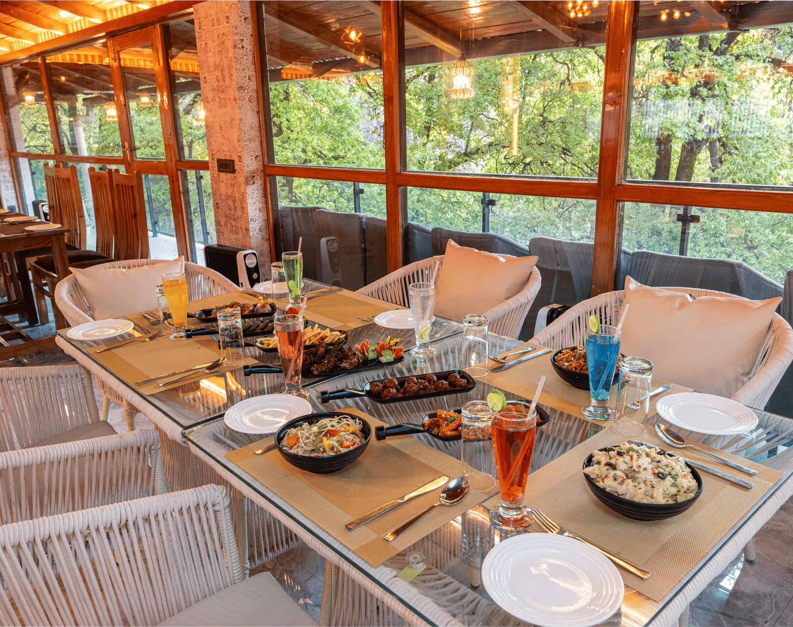 An image of the restaurant chairs and tables with food platters laid on it - DLS The Emerald, Nainital